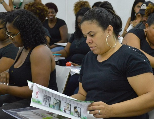 A aluna lê o informativo sobre os cursos de qualificação oferecidos pelo IFRJ e pelo Instituto Profissionalizante da Mangueira