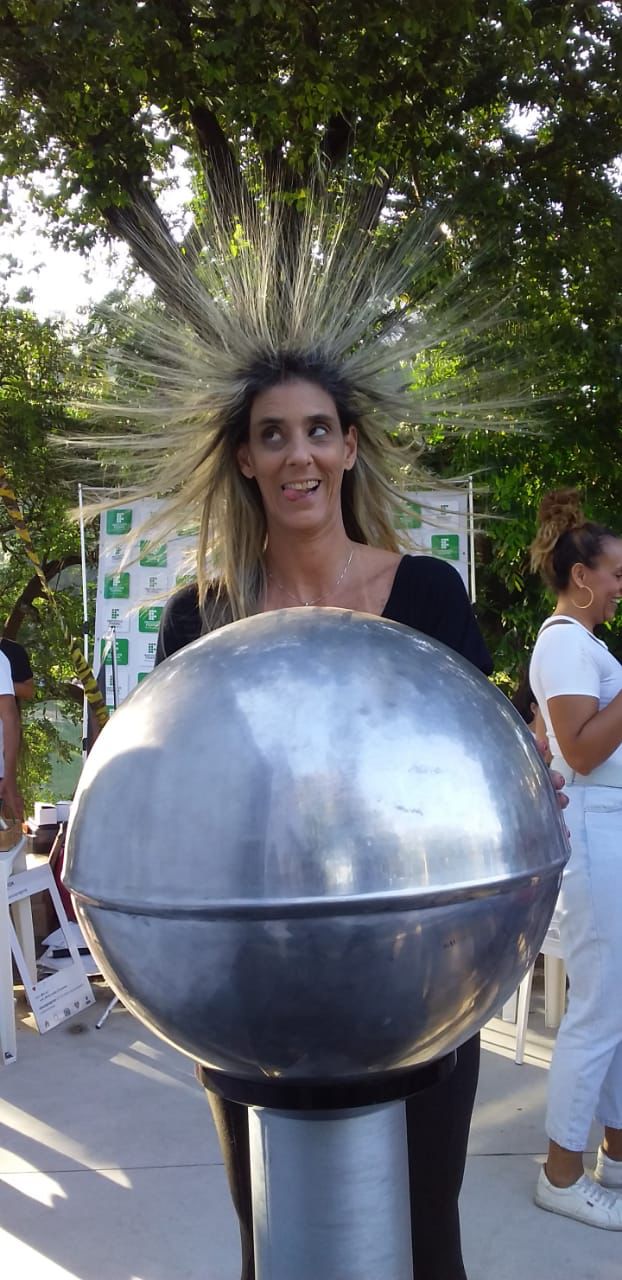 foto de uma mulher recebendo uma descarga elétrica nos cabelos em experimento científico