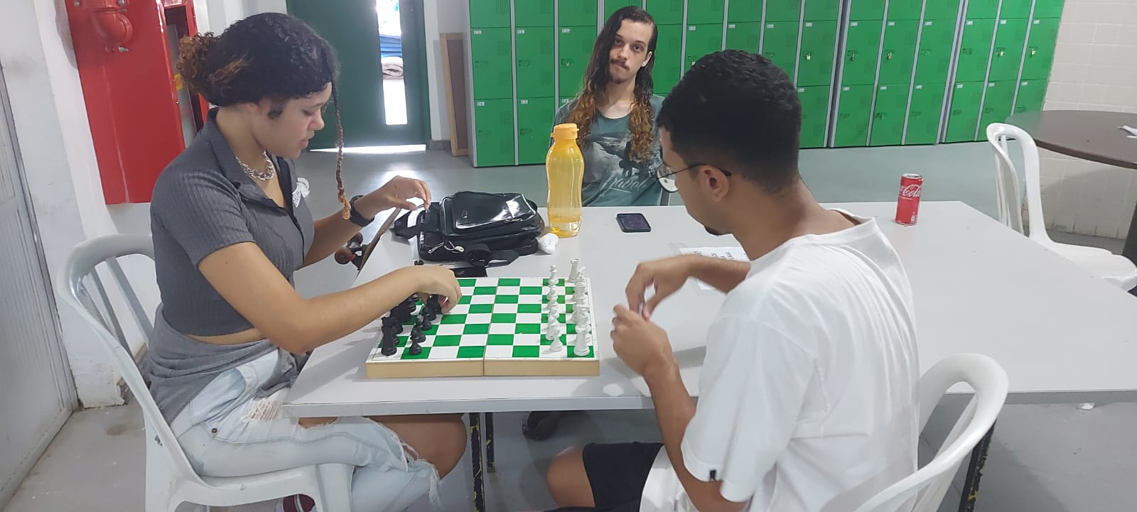 alunos sentados jogam xadrex