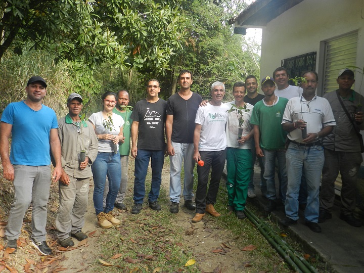 Participantes do curso posam com mudas de plantas nas mãos