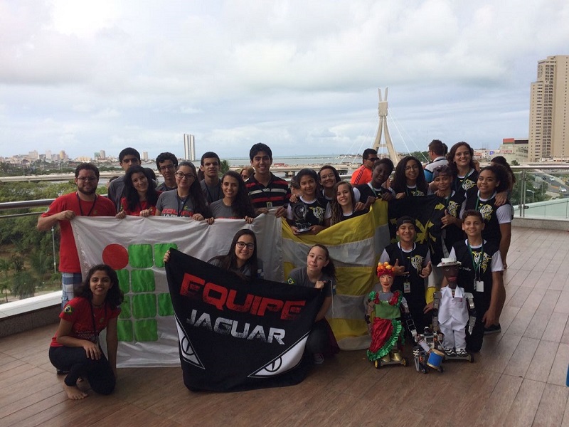 Integrantes da Equipe Jaguar posam para foto com bandeiras do grupo e do IFRJ